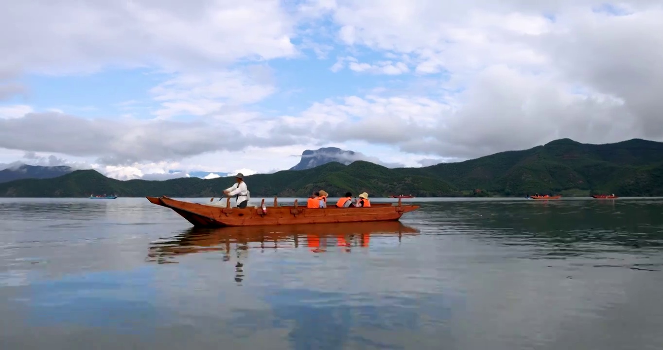 旅游景区：游船在飘满水性杨花的泸沽湖泛舟前行视频素材