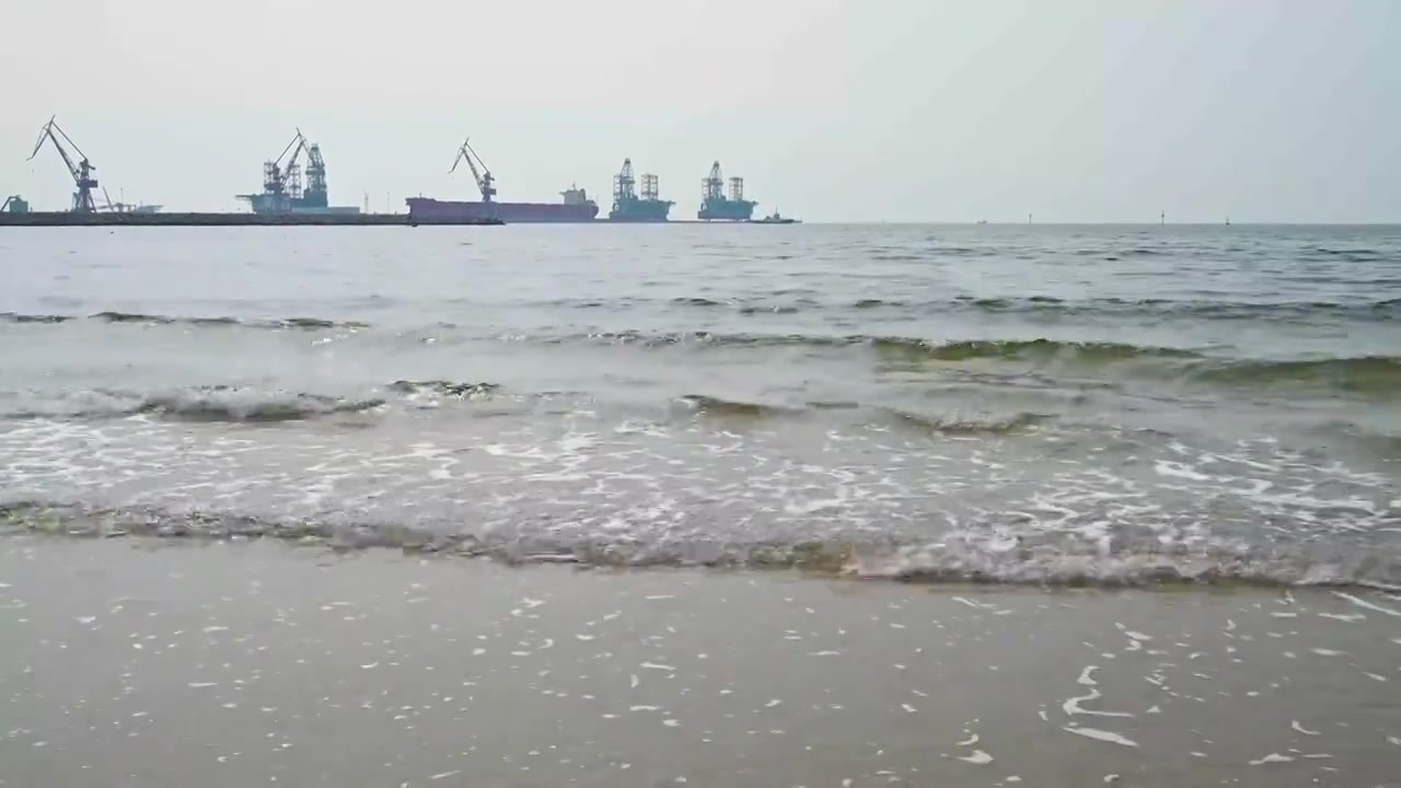 阴天渤海码头海边沙滩与海浪视频素材