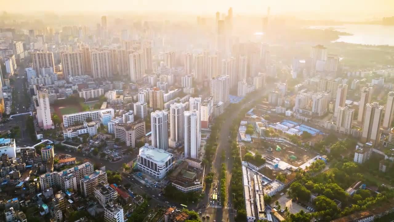 海南海口高视角航拍俯瞰金色阳光下城市交通建筑风景视频素材画面1