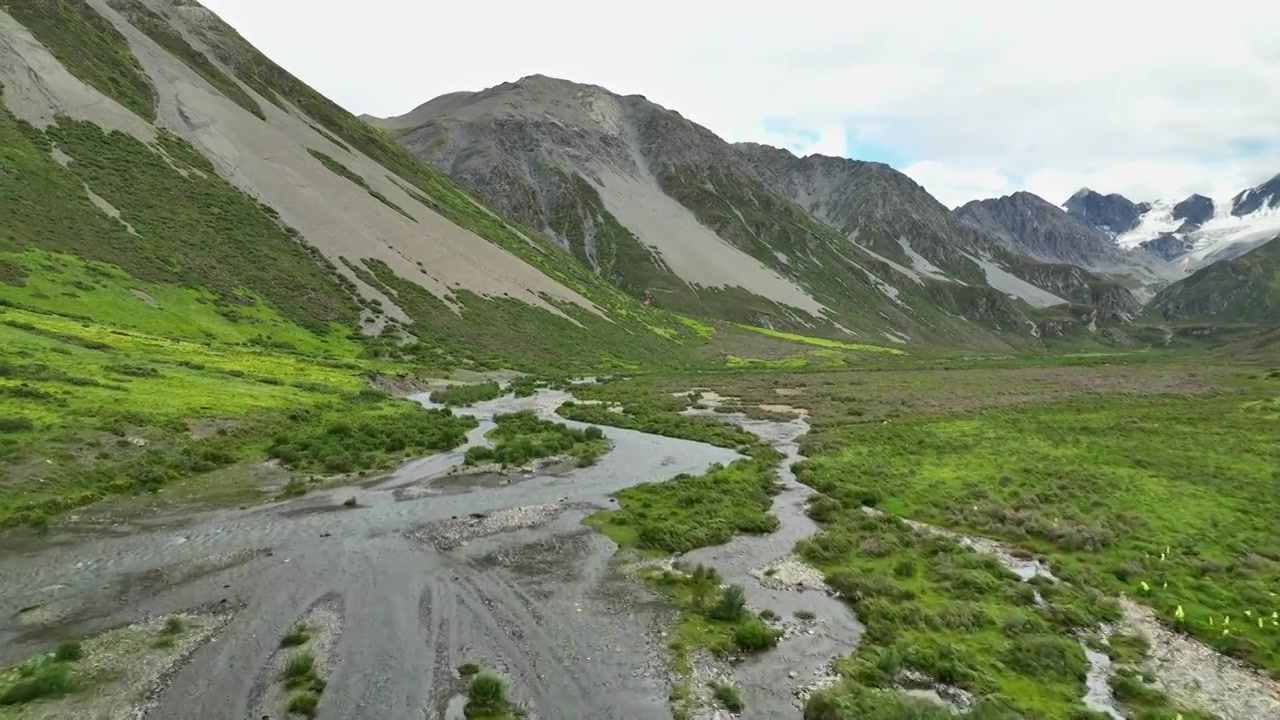 航拍四川甘孜理塘阿萨贡格雪山下的草原河流视频素材