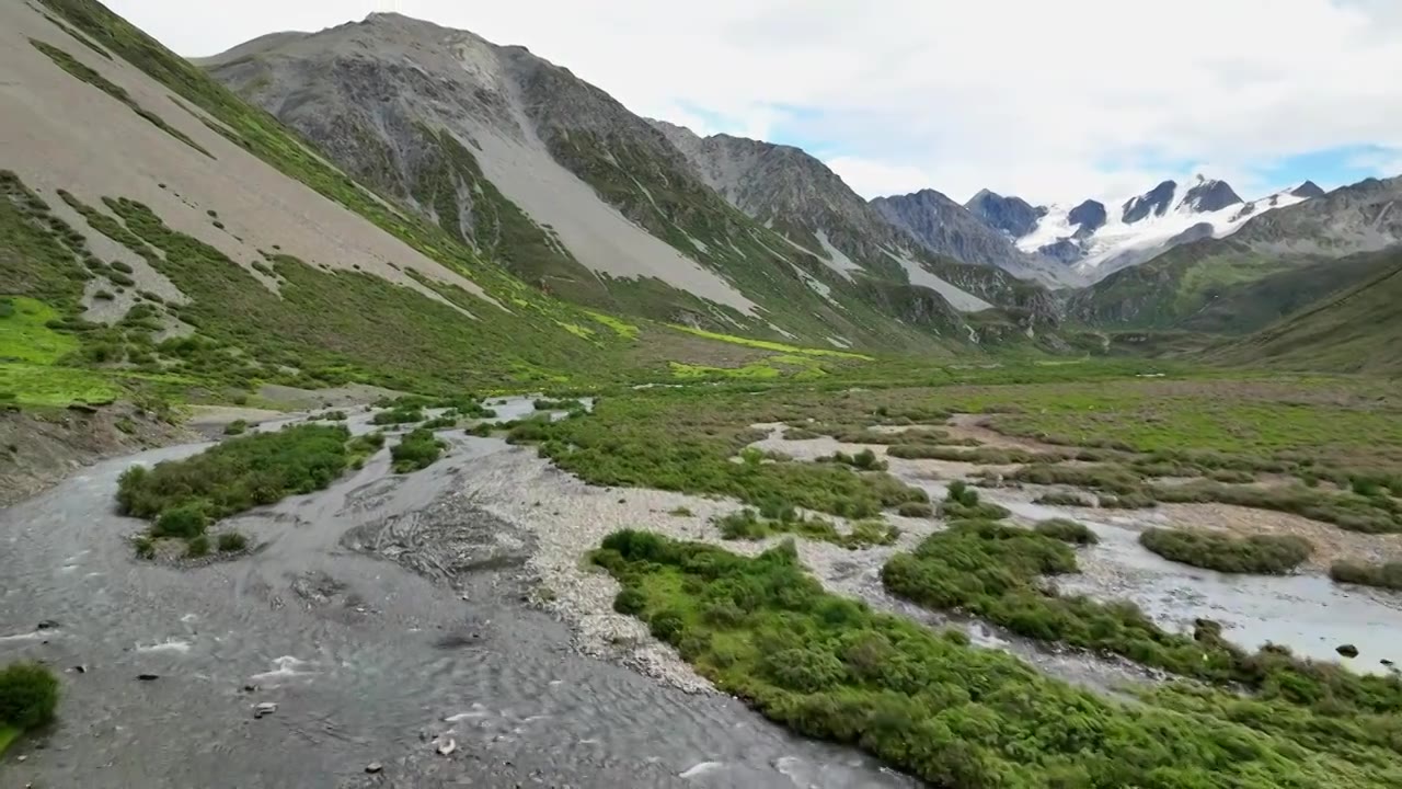 航拍四川甘孜理塘阿萨贡格雪山下的草原河流视频素材