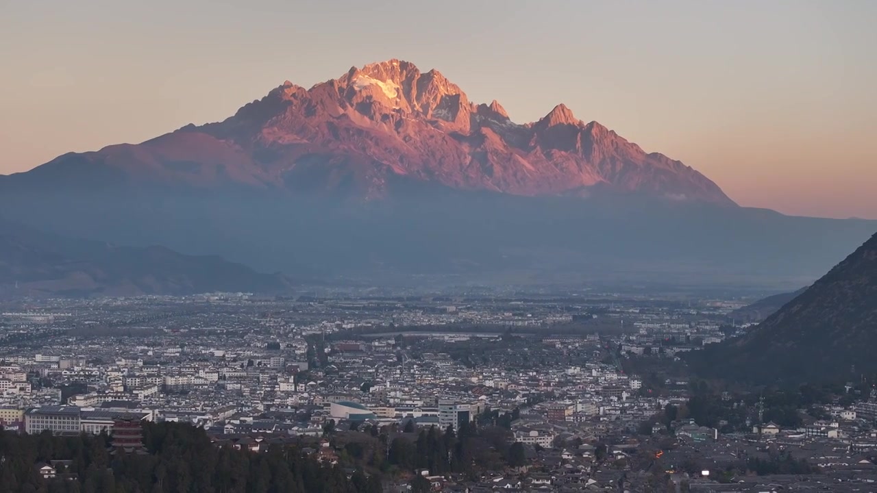 航拍视角下的云南丽江玉龙雪山日出日照金山和城市天际线视频素材