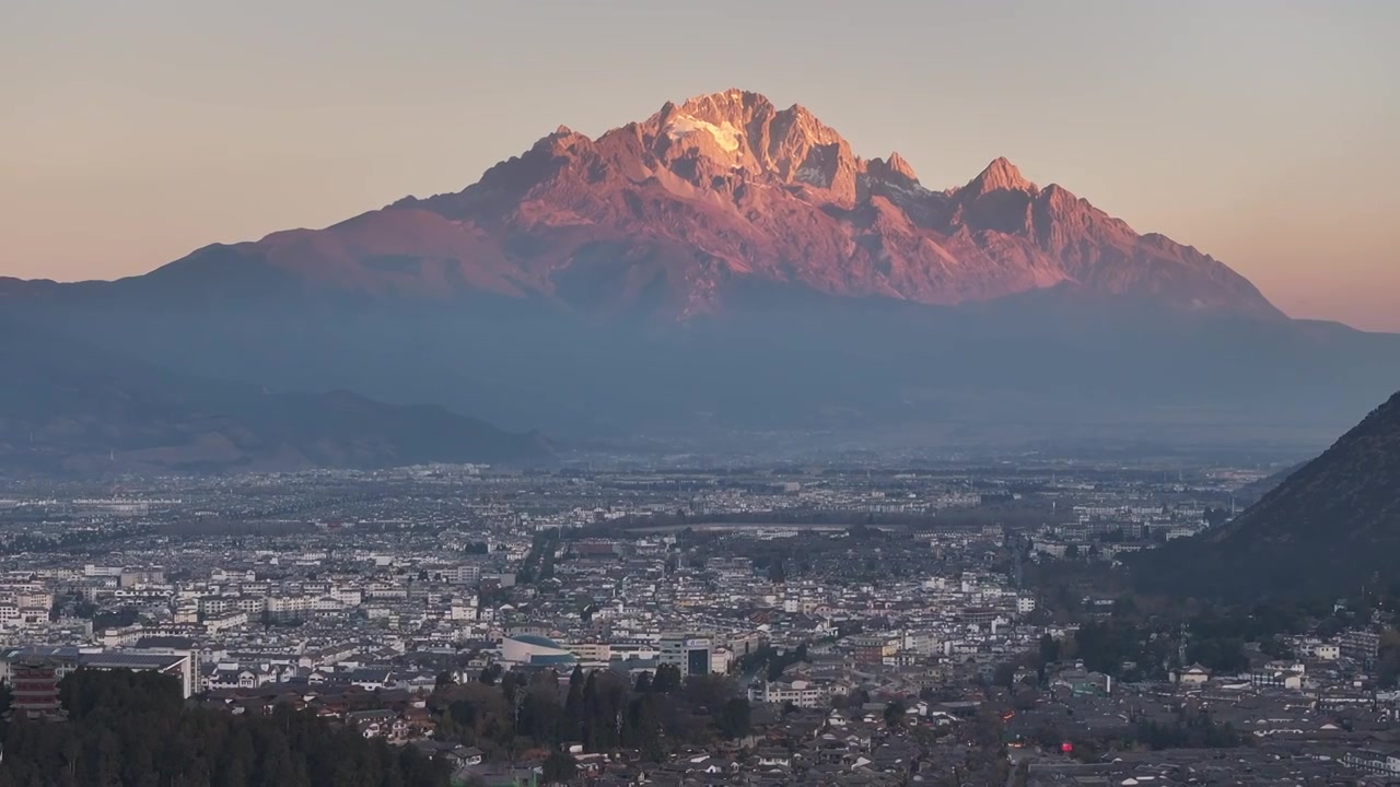 航拍视角下的云南丽江玉龙雪山日出日照金山和城市天际线视频素材