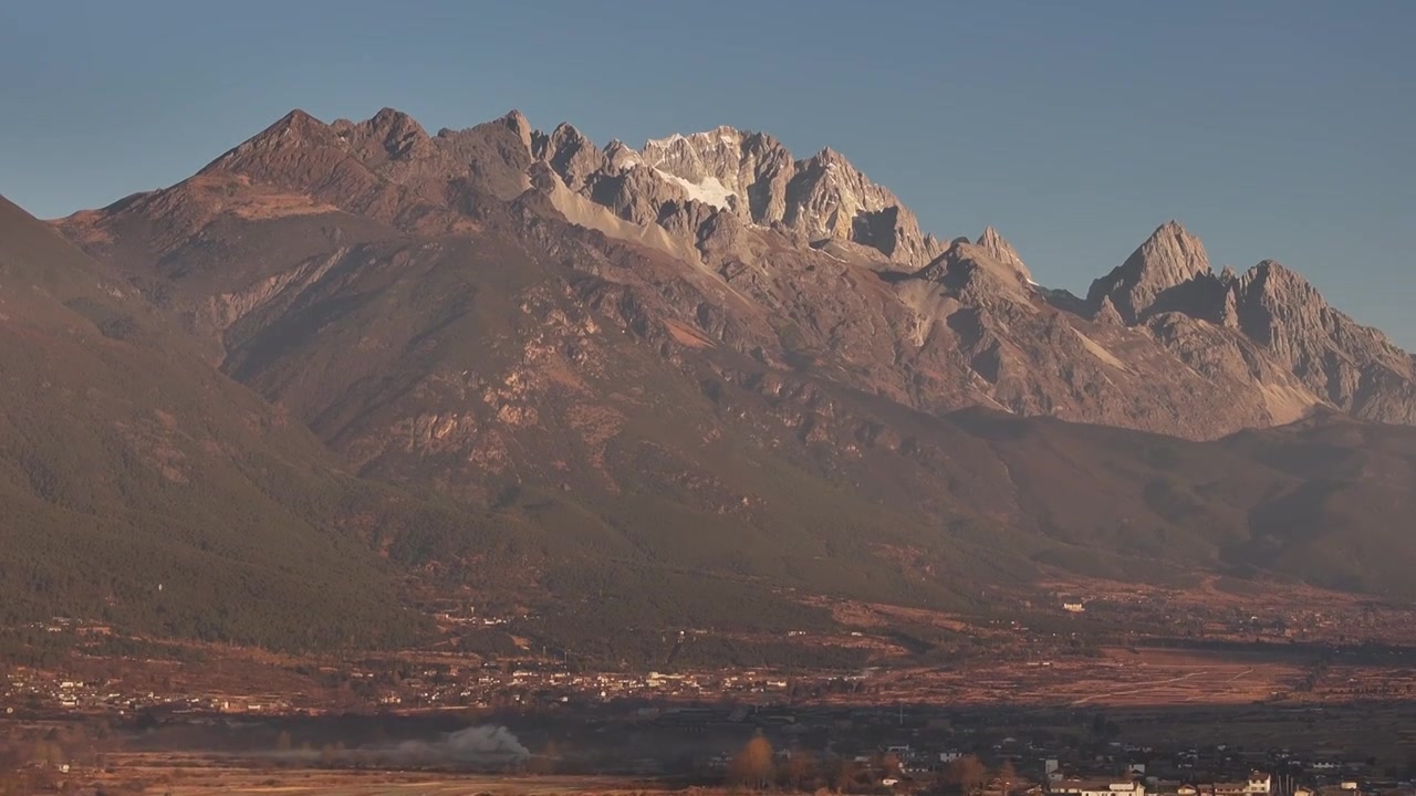 航拍视角下的云南丽江玉龙雪山和乡村日出风光视频素材