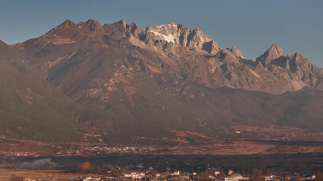 航拍视角下的云南丽江玉龙雪山和乡村日出风光视频素材