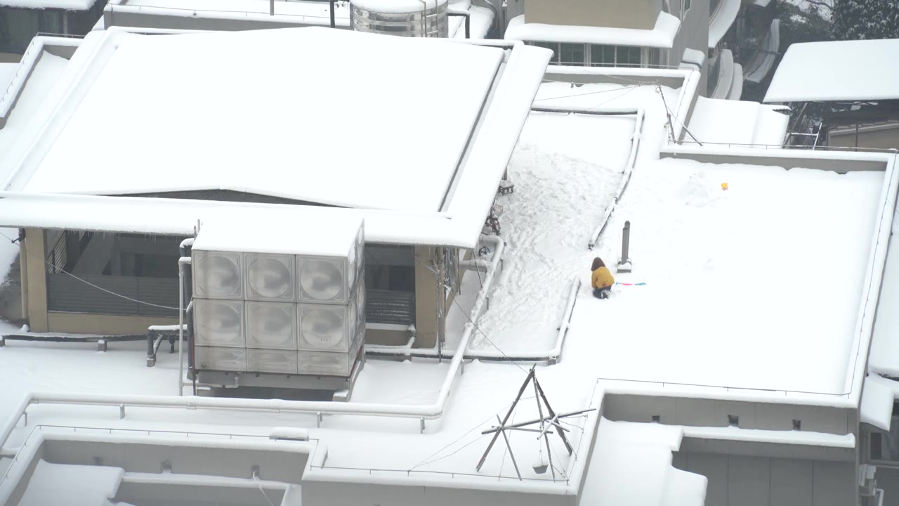 冬天城市雪景建筑楼顶雪地上玩耍的儿童视频素材