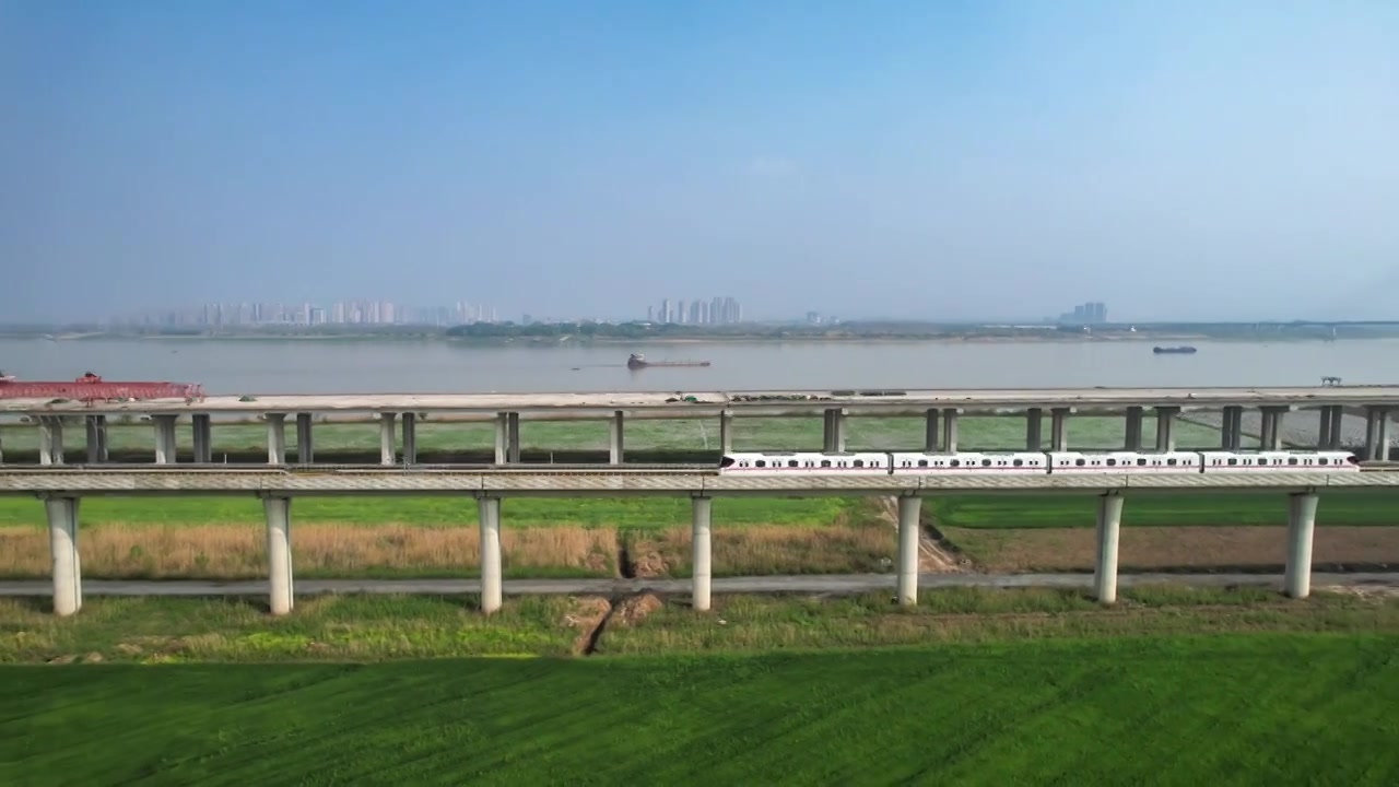 春天里的地铁，像一条银色的丝带，穿越城市的高楼大厦后，来到地面，穿梭在春天绿色的大地间。视频下载