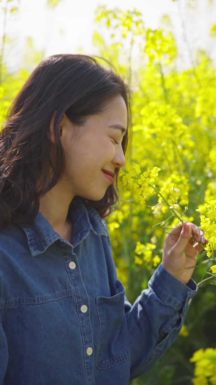 油菜花海里赏花的美女特写春天阳光温暖视频素材