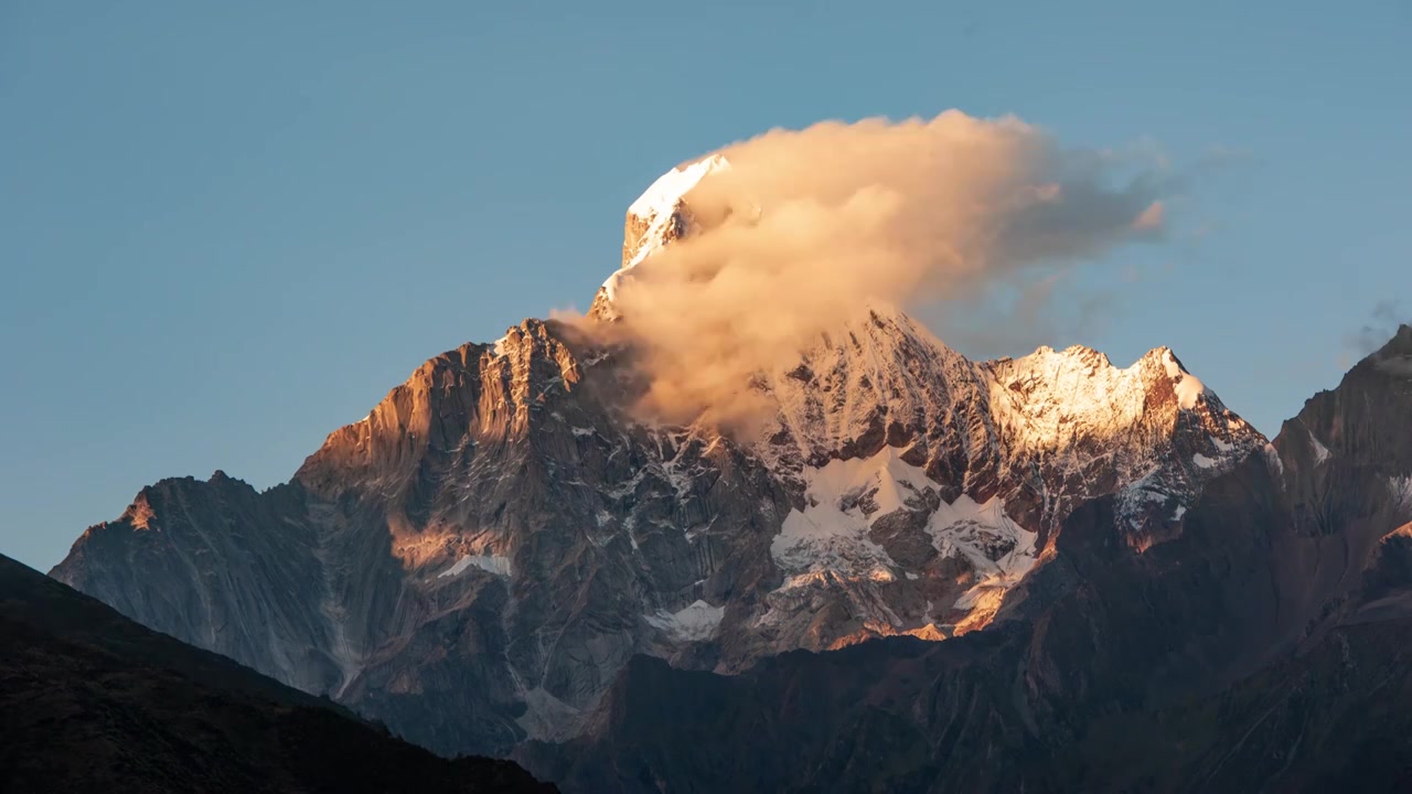 四姑娘山，金色阳光映照，云彩悠然飘荡。视频下载