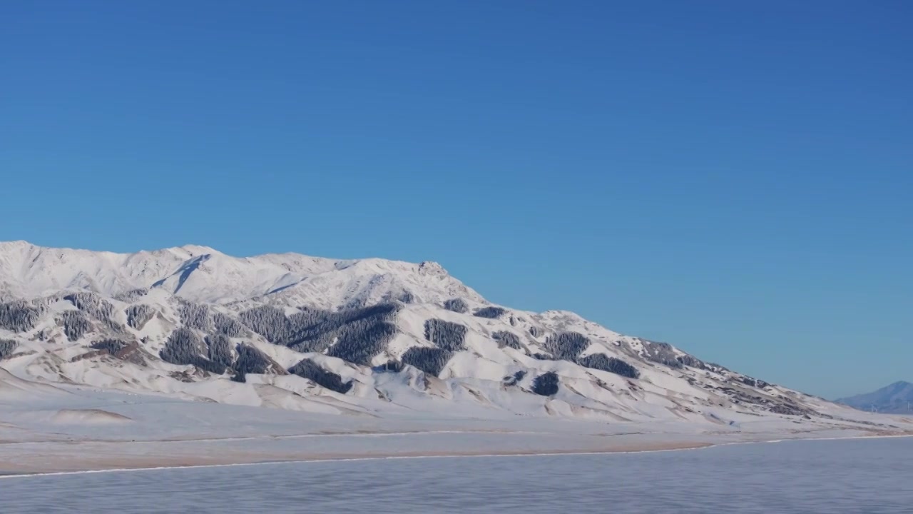 航拍冬季新疆赛里木湖夕阳雪山纹理日照金山视频素材