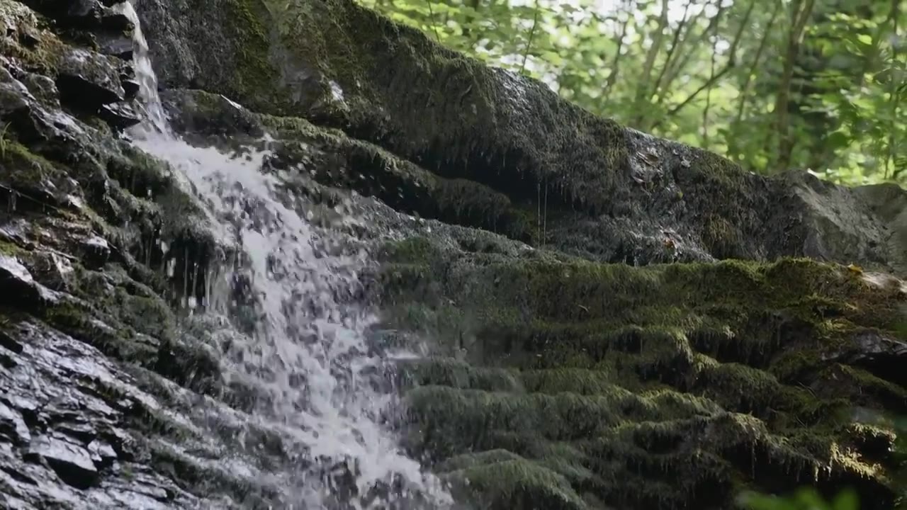 奔涌的小溪。有创造力。山上的大石头上有一个冷泉视频素材