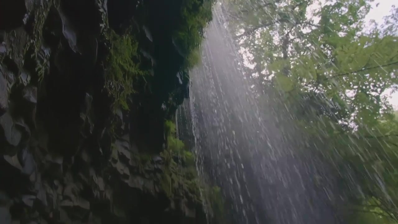 一股水流缓慢地沿着岩石流下。有创造力。小溪的流量视频素材