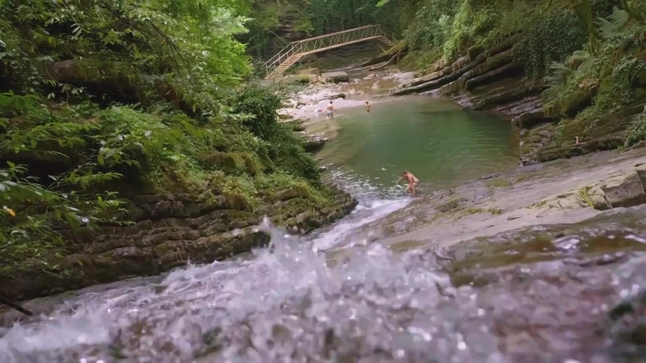 一条小山河在丛林中流淌。有创造力。褐色的石头视频素材