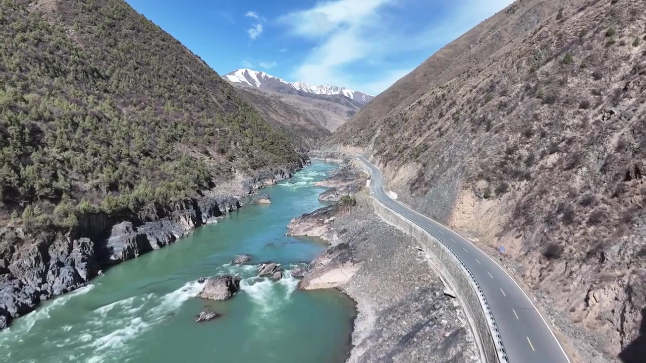 雪山峡谷间的金沙江边有一条道路通向远方视频素材