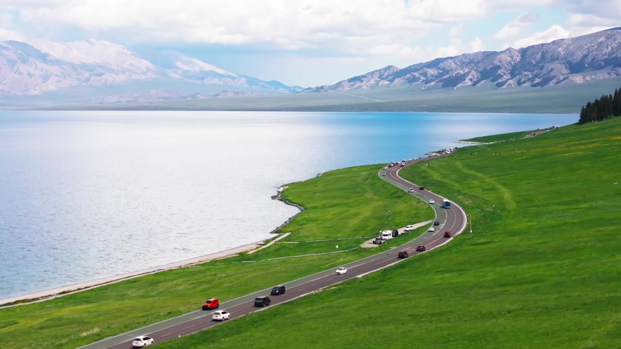 新疆伊犁赛里木湖环湖旅游公路和周围雪山草原视频素材