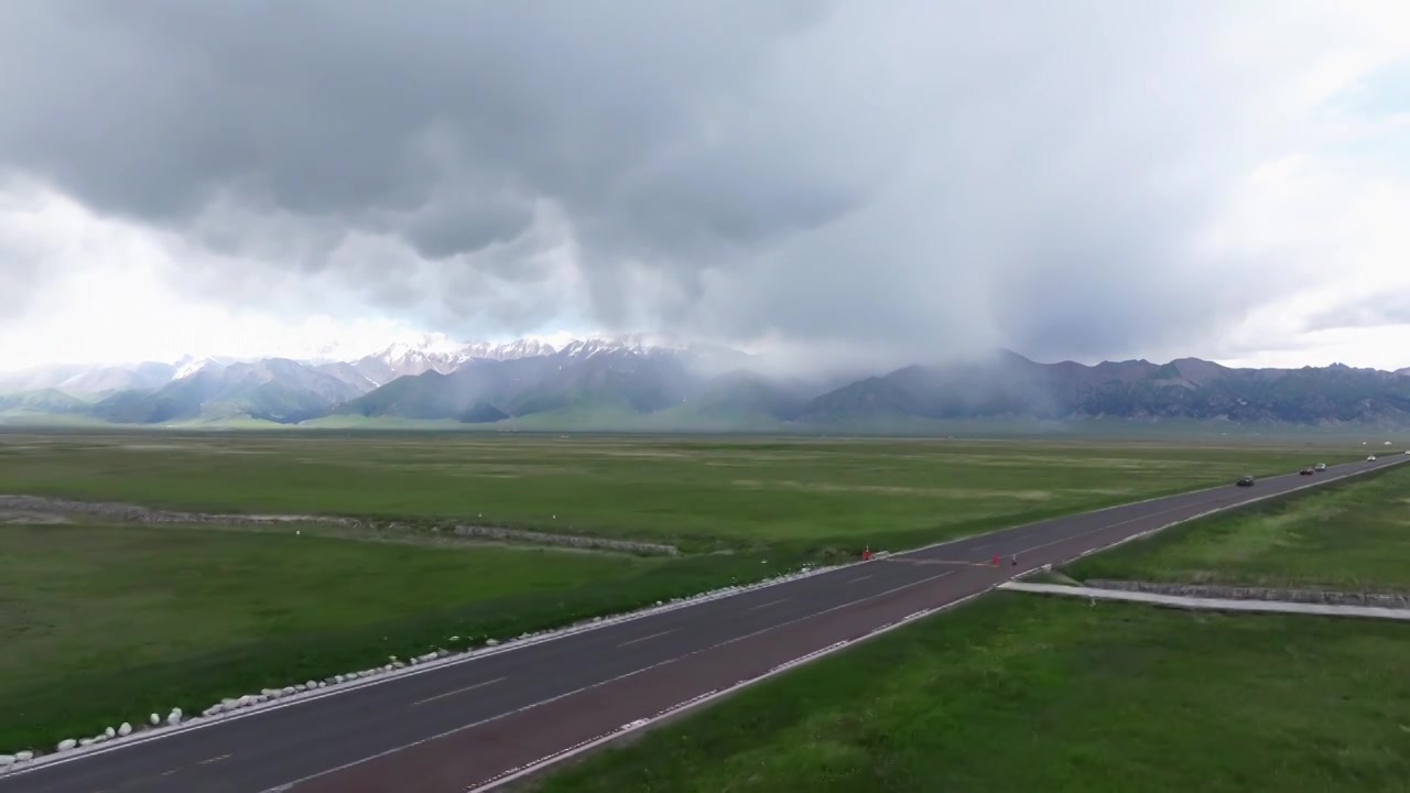 新疆伊犁赛里木湖环湖旅游公路和周围雪山草原视频素材