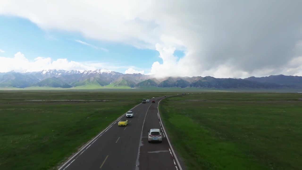 新疆伊犁赛里木湖环湖旅游公路和周围雪山草原视频素材