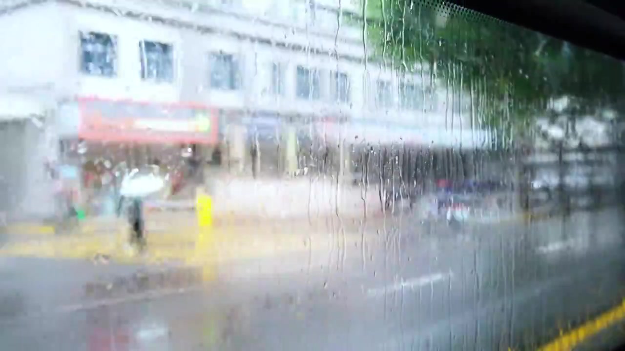 车窗向外看，模糊，雨滴，城市街景。视频素材