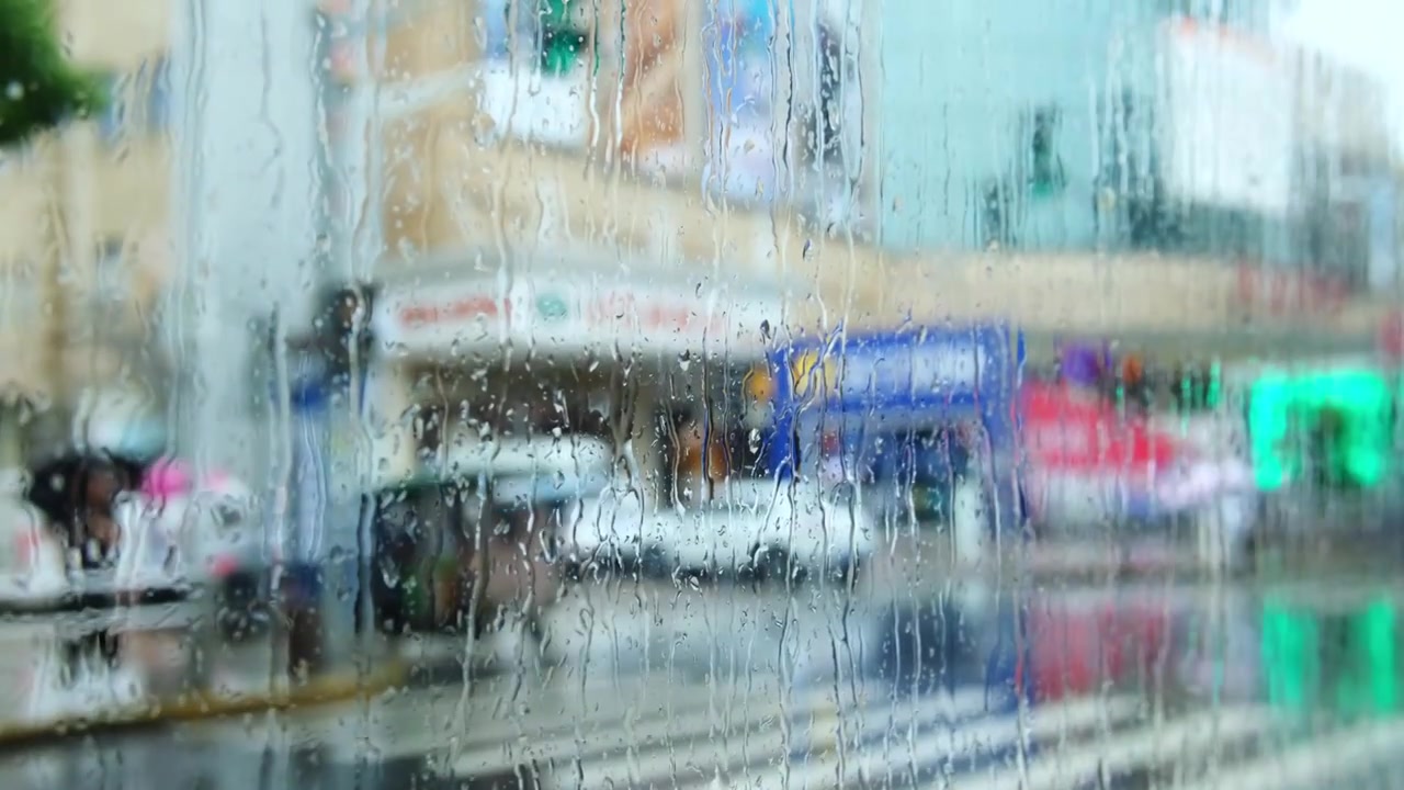 车窗向外看，模糊，雨滴，城市街景。视频素材