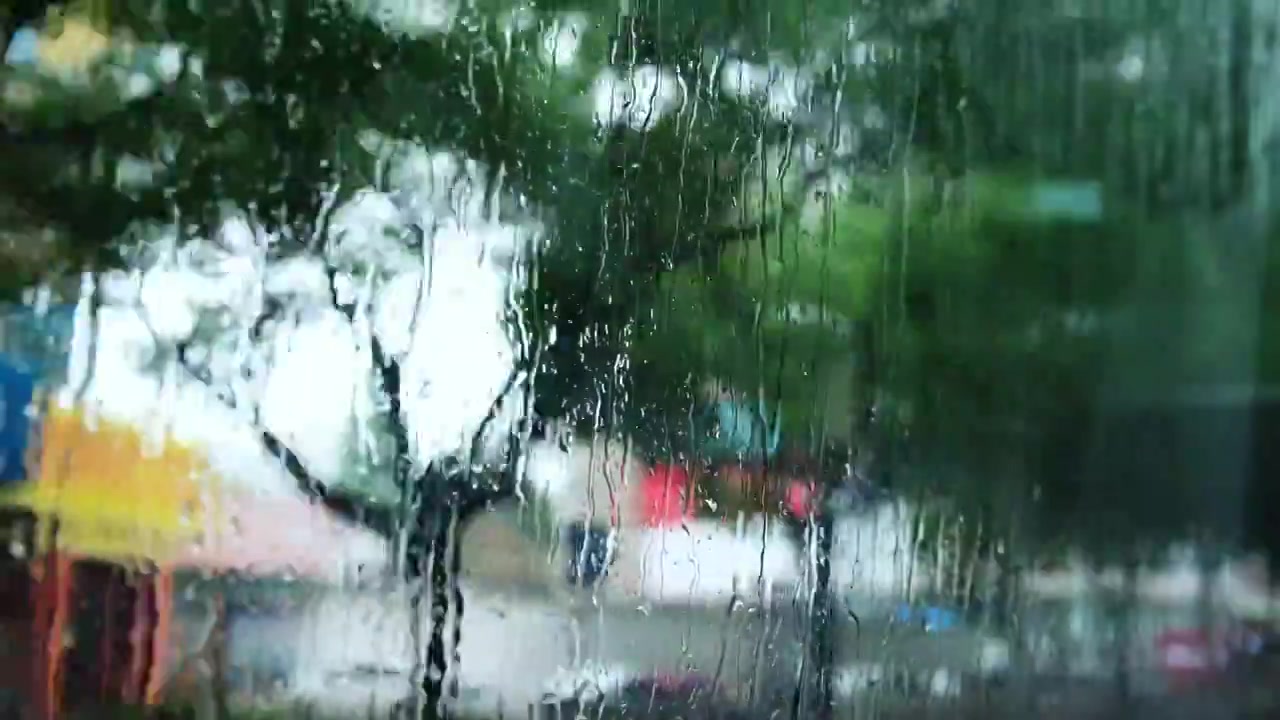 车窗向外看，模糊，雨滴，城市街景。视频素材