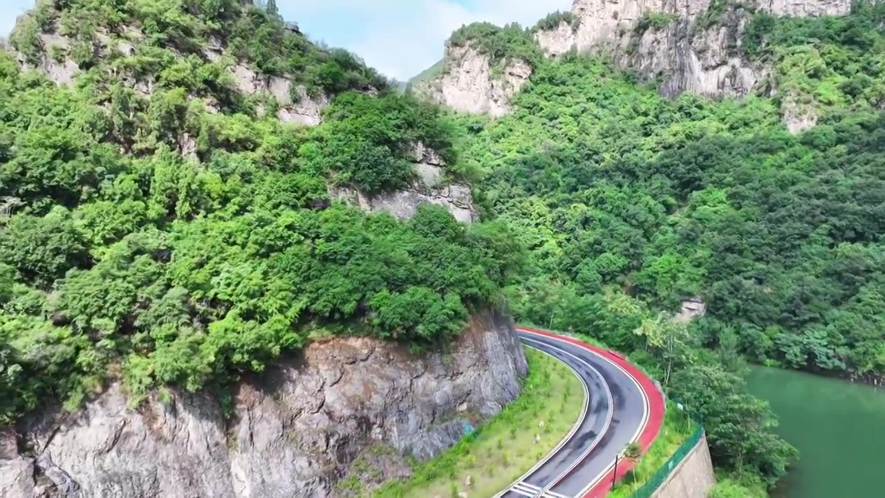 郑州市巩义市浮戏山雪花洞小龙池景区碧绿色溪流旁边的旅游公路视频素材