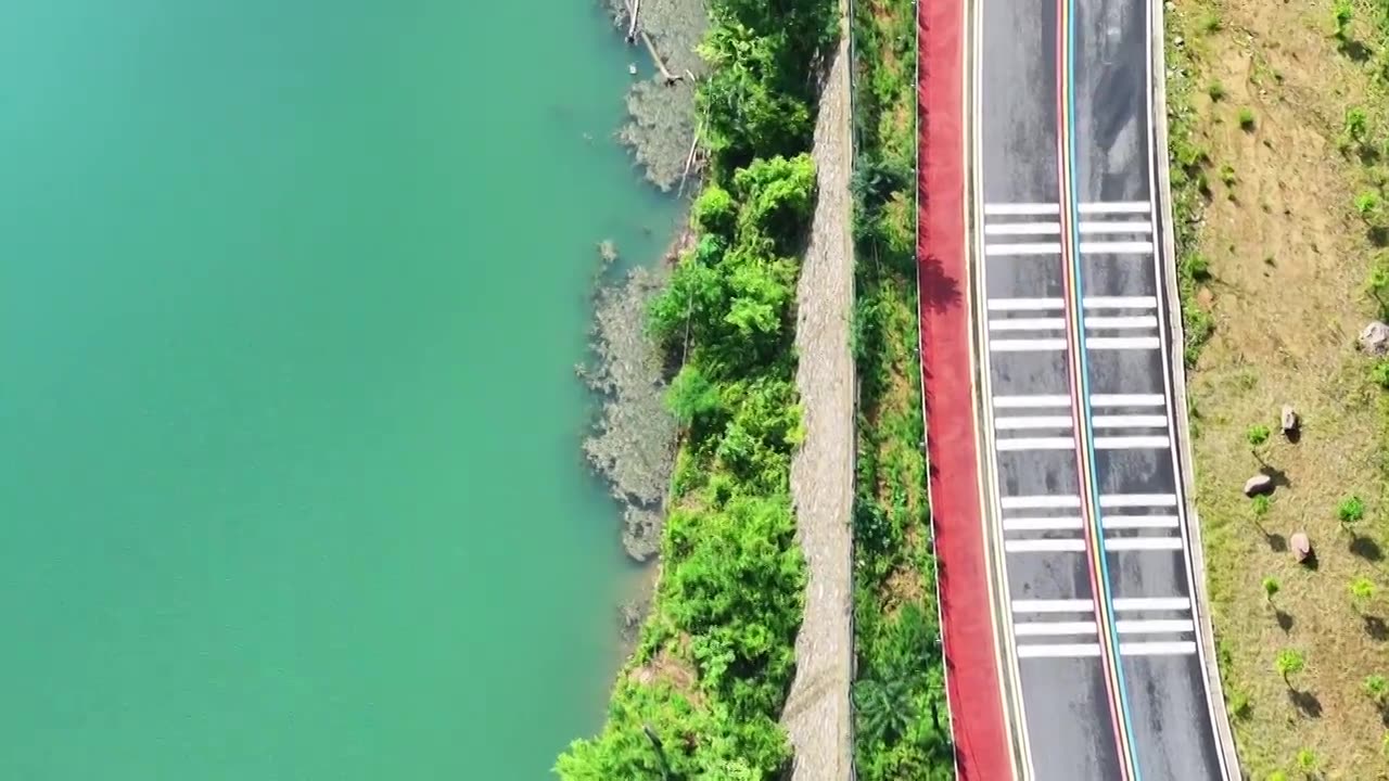 郑州市巩义市浮戏山雪花洞小龙池景区碧绿色溪流旁边的旅游公路视频素材