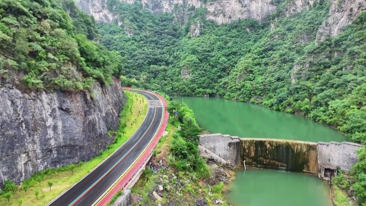 郑州市巩义市浮戏山雪花洞小龙池景区碧绿色溪流旁边的旅游公路视频素材