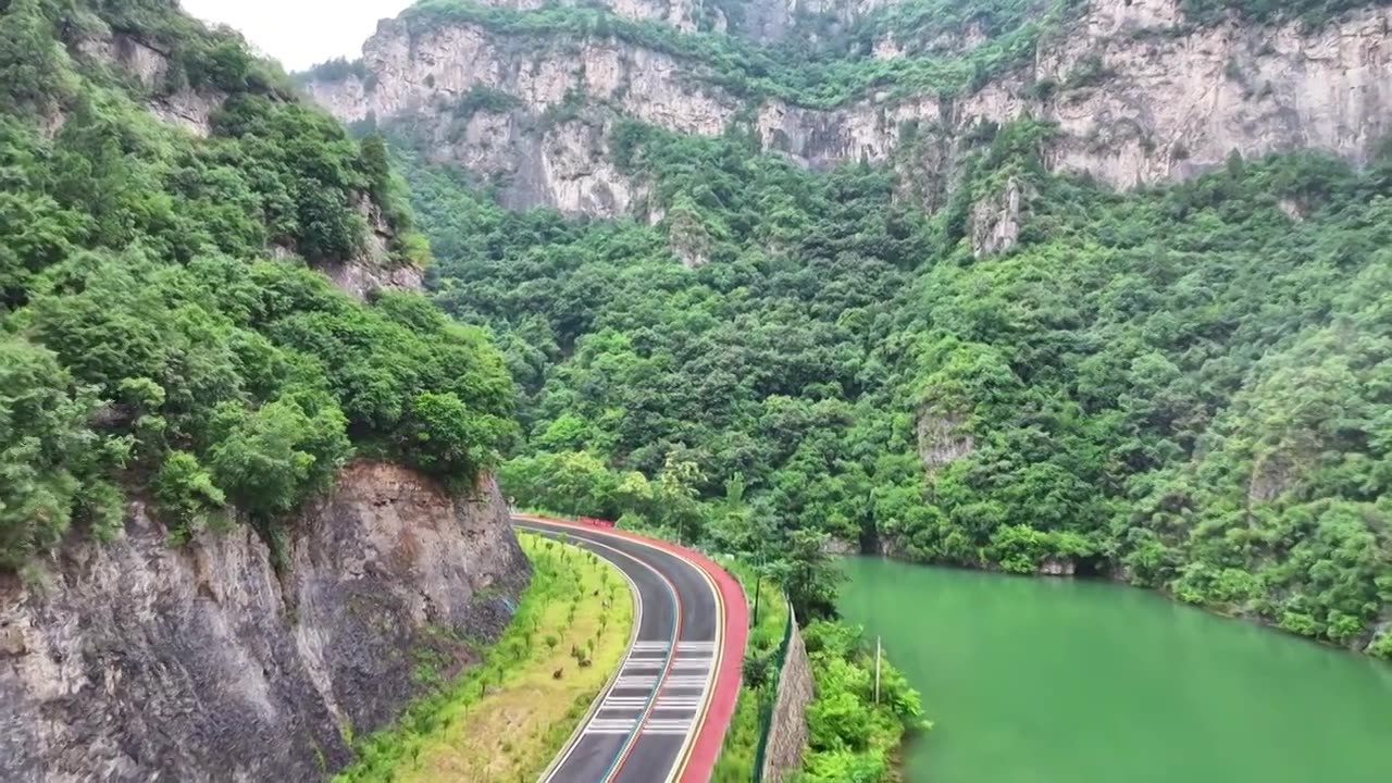 郑州市巩义市浮戏山雪花洞小龙池景区碧绿色溪流旁边的旅游公路视频素材