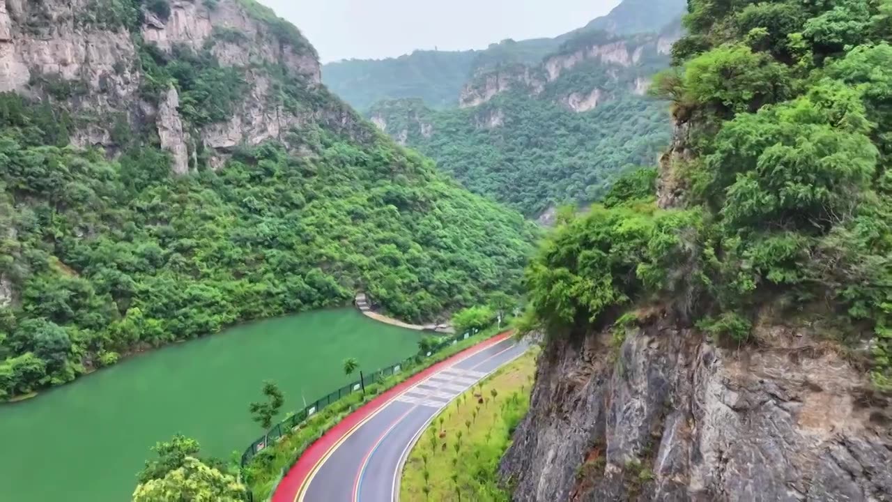 郑州市巩义市浮戏山雪花洞小龙池景区碧绿色溪流旁边的旅游公路视频素材