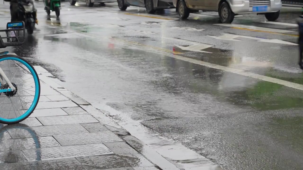 下雨天暴雨天气电动车路过街道积水溅起水花慢镜头视频素材