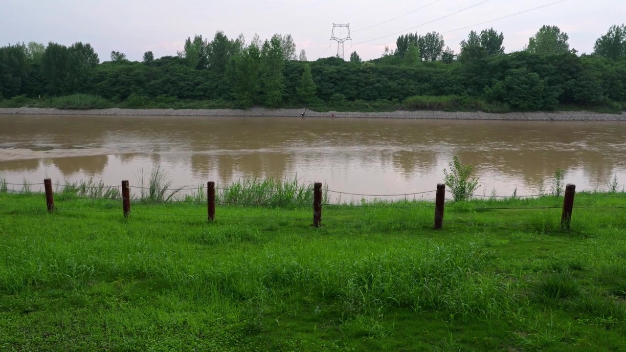 连续多日的雨季让陕西西安境内河流的水位暴涨，清水河变成了混浊的浊水河，河水与岸边的绿色草地视频下载