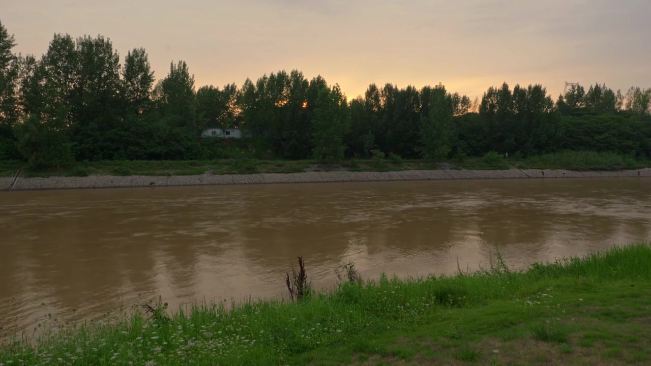 连续多日的雨季让陕西西安境内河流的水位暴涨，清水河变成了混浊的浊水河，河水与岸边的绿色草地视频下载