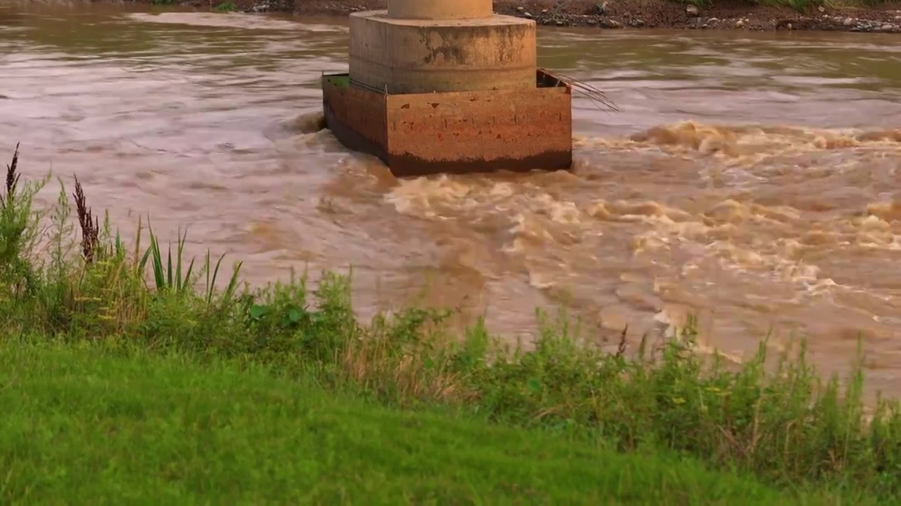 连续多日的雨季让陕西西安境内的河流水位暴涨，清水河变成了浑浊的河水，桥墩下奔流的洪水视频下载