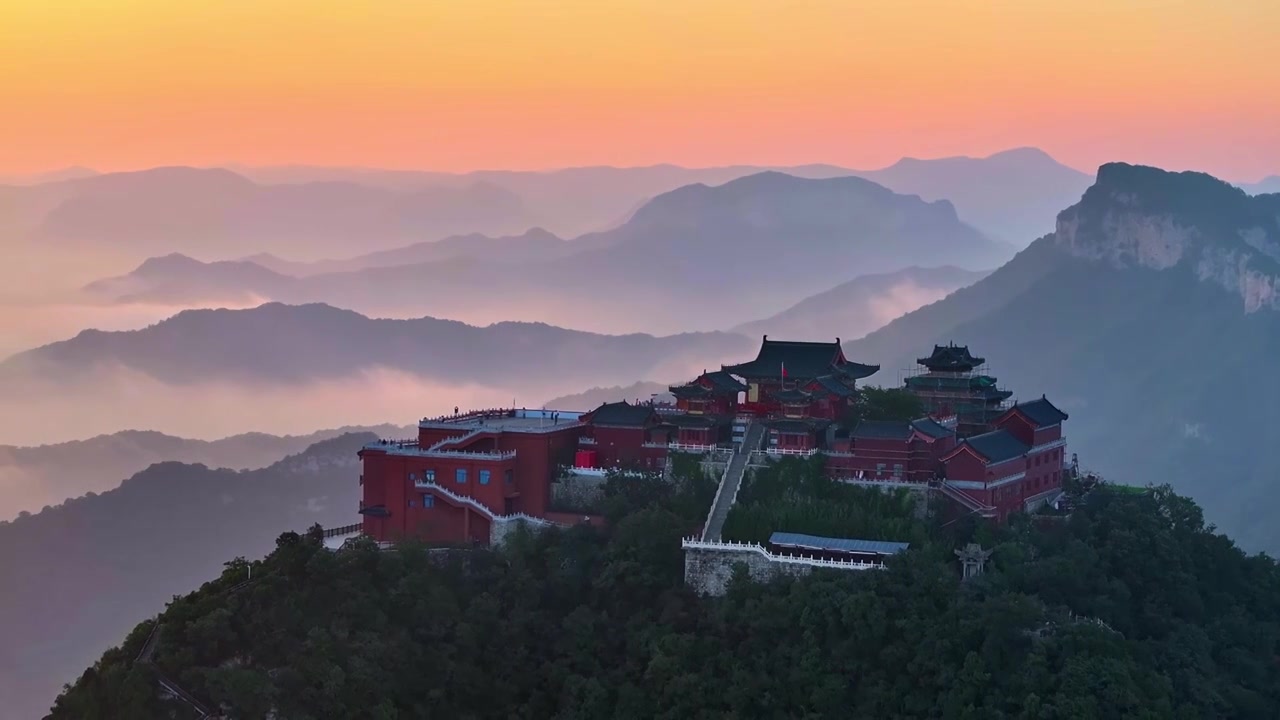 航拍云台山茱萸峰道教建筑群和远处的落日云海视频素材