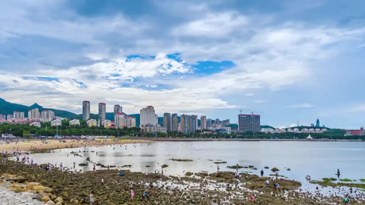 山东烟台海昌渔人码头风景区夏季退潮赶海的游客视频素材