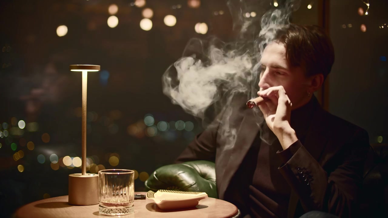 年轻人在餐厅抽雪茄。媒体。穿着西装的优雅男士在屋里抽雪茄视频素材画面3