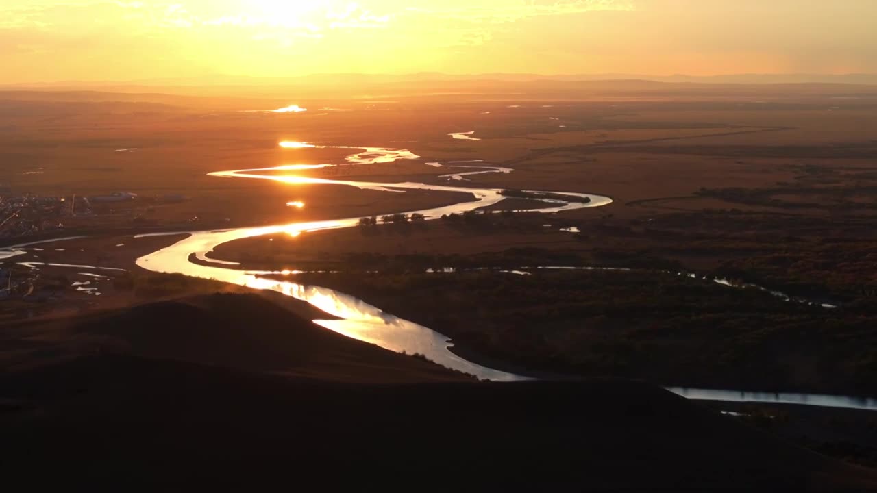 夕阳下蜿蜒曲折的河流和湿地视频素材画面1