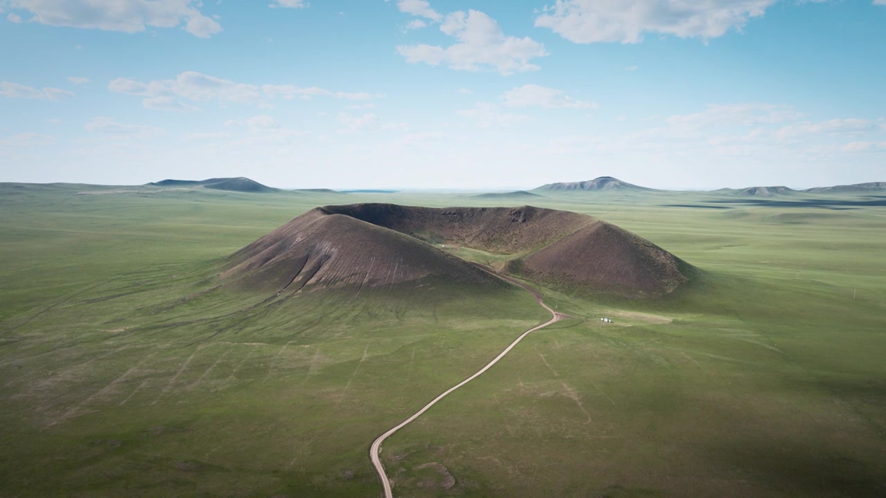 航拍锡林浩特马蹄口火山，草原巨型火山锥与环形火山口、蜿蜒土路的地质全景风光视频素材画面3
