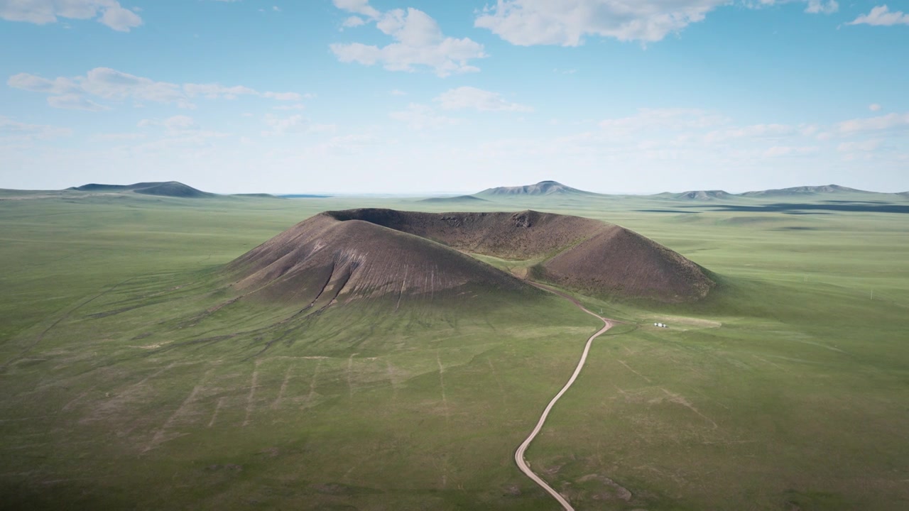 航拍锡林浩特马蹄口火山，草原巨型火山锥与环形火山口、蜿蜒土路的地质全景风光视频素材画面4