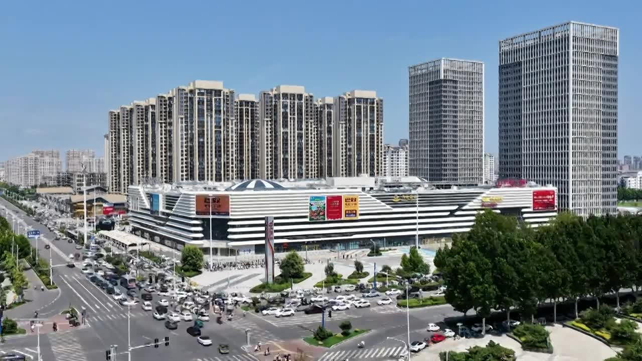 河南省周口市川汇区，大庆路与文昌大道交叉口文昌万达广场商场与周边交通环境延时摄影。视频素材画面1