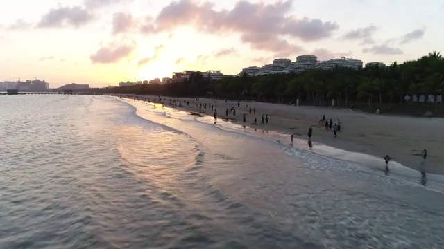 航拍文昌高隆湾夕阳下玩耍的人群视频素材