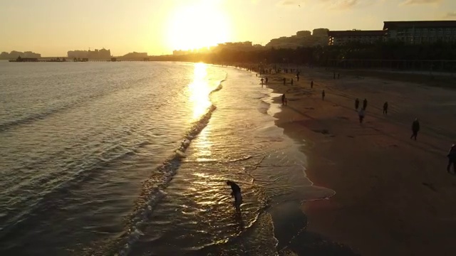 航拍文昌高隆湾夕阳下玩耍的人群视频素材