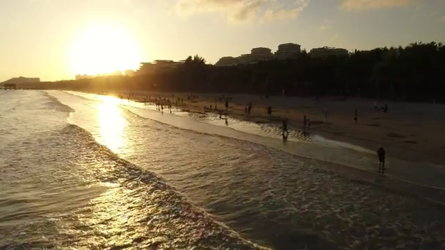 航拍文昌高隆湾夕阳下玩耍的人群视频素材