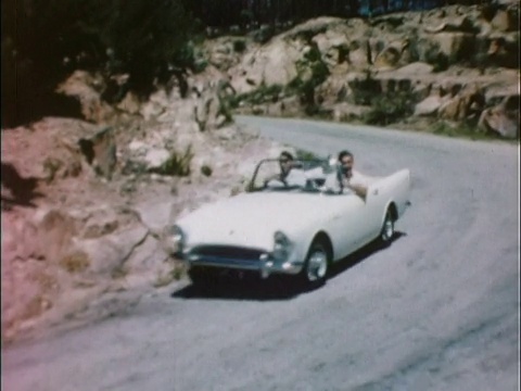 1959年WS PAN White 1959 Sunbeam Alpine驾驶在蜿蜒的道路上/英国视频素材