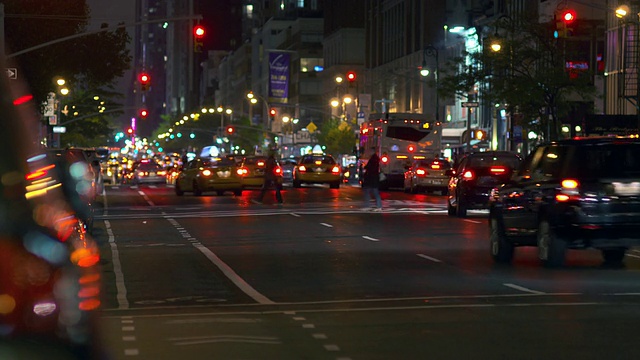 夜间车辆在第六大道上行驶。出租车、小汽车和公共汽车都朝时代广场开去。视频素材