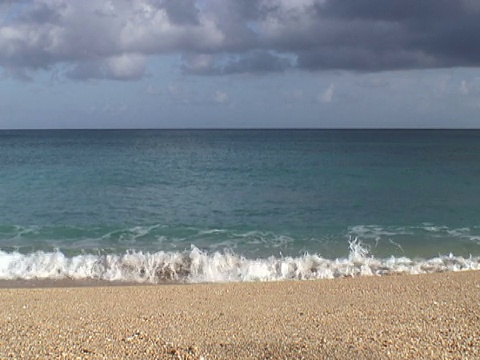 海浪拍打着金色的海滩视频素材