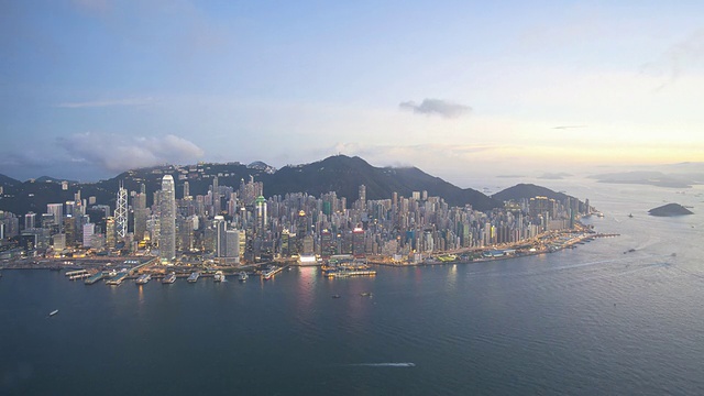 从早到晚，鸟瞰香港岛至太平山顶繁忙的维多利亚港和中国香港中环的金融区，延时拍摄视频素材