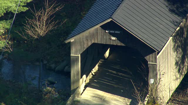 CU AERIAL ZI ZO Cars穿过Pine Brook Covered Bridge / Vermont，美国视频素材