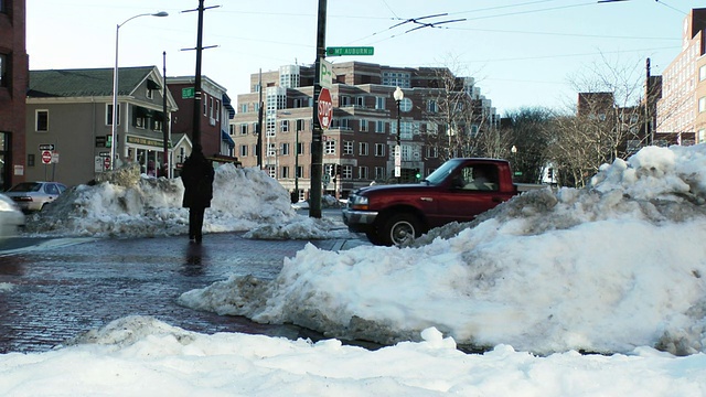 美国马萨诸塞州波士顿市，汽车在泥泞的城市街道上穿过被雪覆盖的人行道视频素材