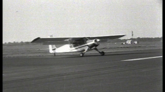 B/W小型螺旋桨飞机在跑道上降落/ Piper Cub飞机/ Teterboro, NJ /无声音视频素材